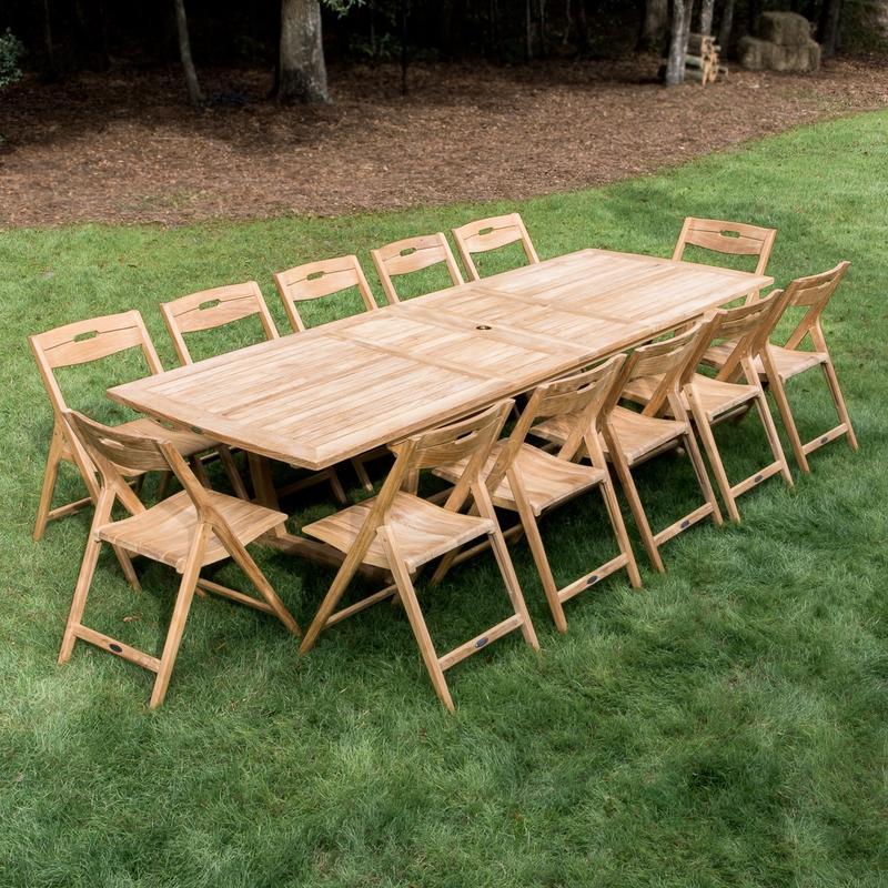 alt="70731 Surf Valencia 13 piece teak rectangular Dining Set of a rectangular extension table and 12 teak dining chairs on grass with mulched area with trees in background"