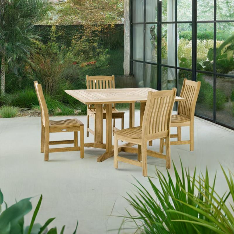 alt="70709 Veranda Pyramid 5 piece Bistro Dining Set of 4 teak side chairs and teak 48 inch square dining table side view on patio surrounded by plants with glass doors and fence in the background "