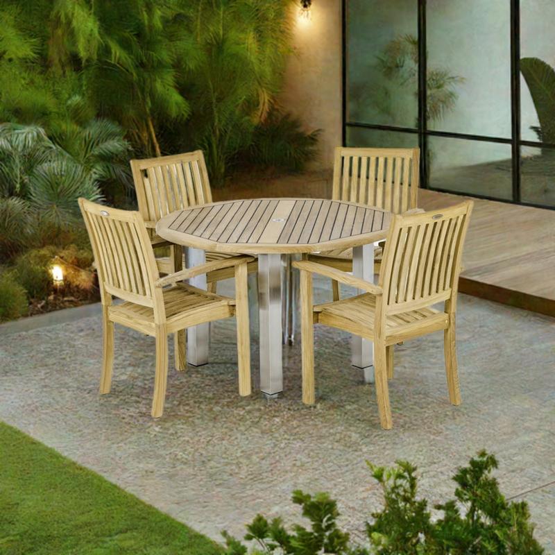alt="70624 Vogue Sussex Dining Set of the Vogue 48 inch Round Dining Table and 4 Sussex Stacking Chairs on patio in front of glass doors and trees in the background"