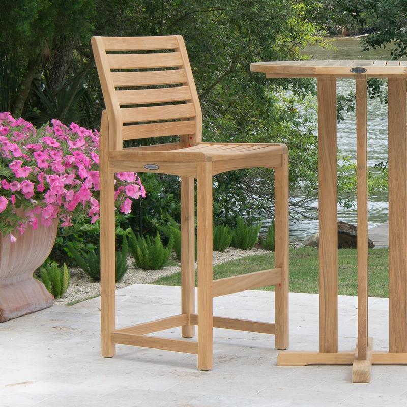 alt="11812 Somerset Side Barstool and 30 inch Teak Bar Table on concrete patio potted flowering plant with lake and trees in background"