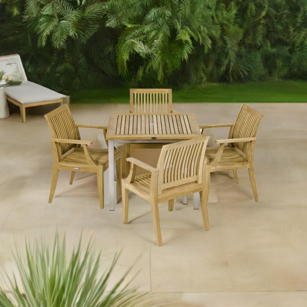 70603 Vogue Laguna 5 pc Dining Set of Vogue Teak 36 inch Square Table and 4 Laguna Dining Arm Chairs angled aerial view on patio with plants and white chaise in the background