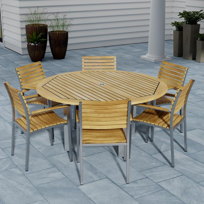 alt="70442 Vogue Teak 7 pc Dining Set showing Vogue 60 inch Round Dining Table and 6 Dining Chairs angled aerial view on patio 4 potted plants against a house in background"