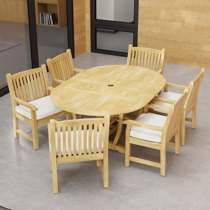 alt="70374 Oval Veranda Chair Dining Set of Martinique Teak Oval Table and 6 Veranda Dining Chairs angled end view on outdoor terrace with a glass door and window in background"