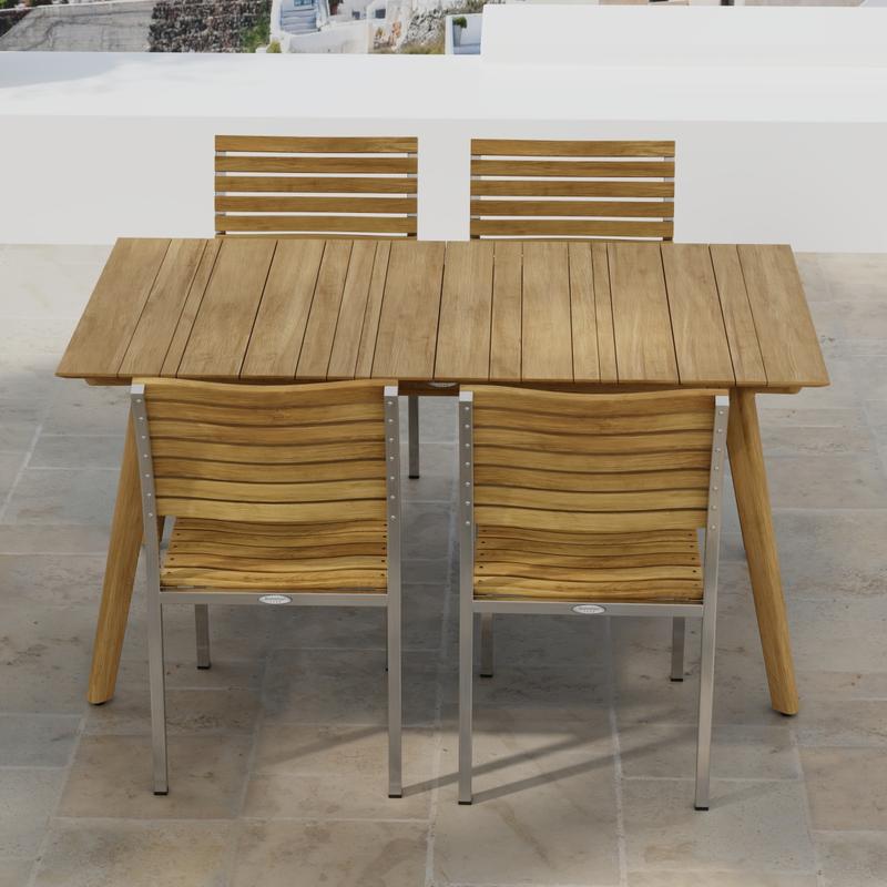 alt="70552 Vogue Surf 5 pc Dining Set of Surf Table and 4 Vogue Side Chairs on an outdoor terrace in angled side view with homes in background"