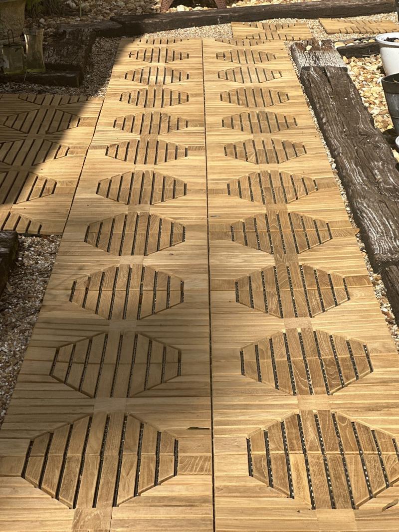 alt="18408P diamond teak tiles assembled together on a walkway in closeup view of design with landscape wood border and rocks on each side"