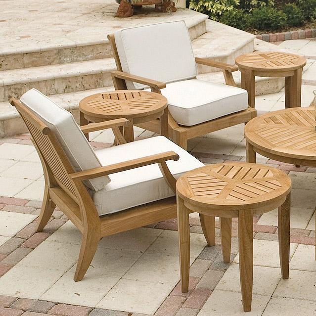alt="14140 laguna teak side table in an eleven piece lounge set with cushions on concrete stone patio and concrete steps and grass landscaping in background"