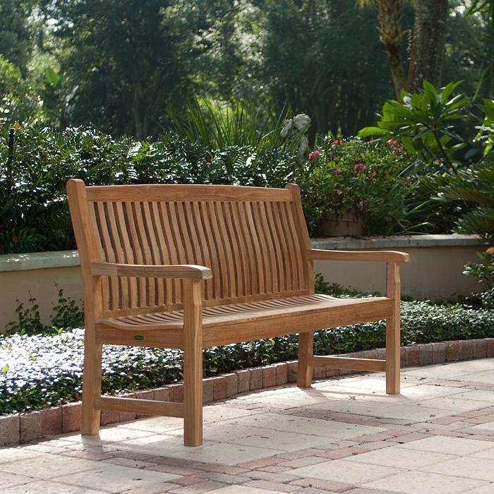 alt="13618 Veranda Teak 5 foot long Bench on concrete stone patio with shrubs and flowers in background"