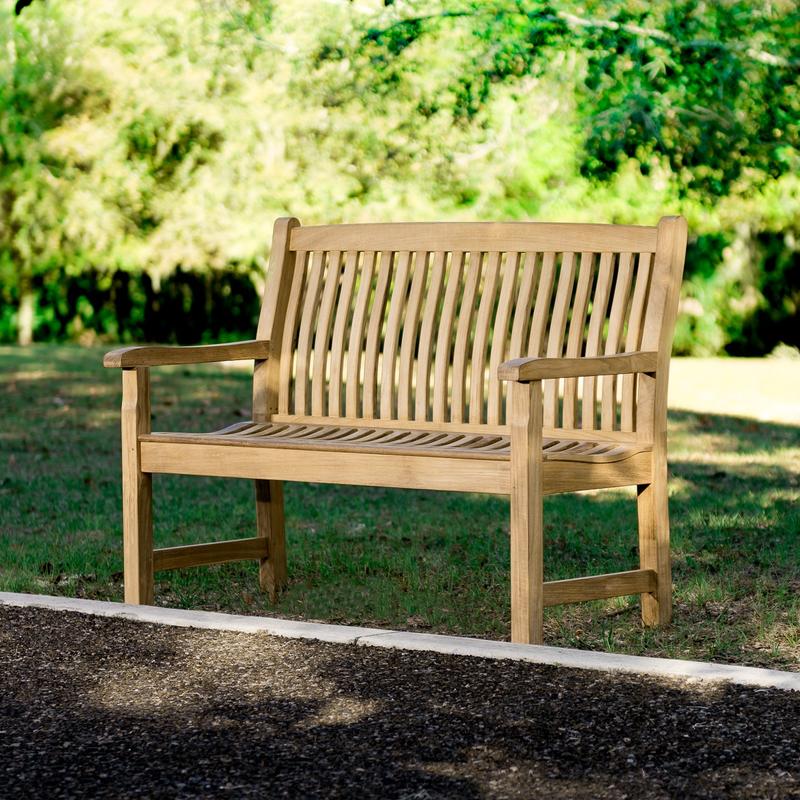 alt="13218 Veranda Teak 4 foot Bench on grass field with garden in front and trees in background"