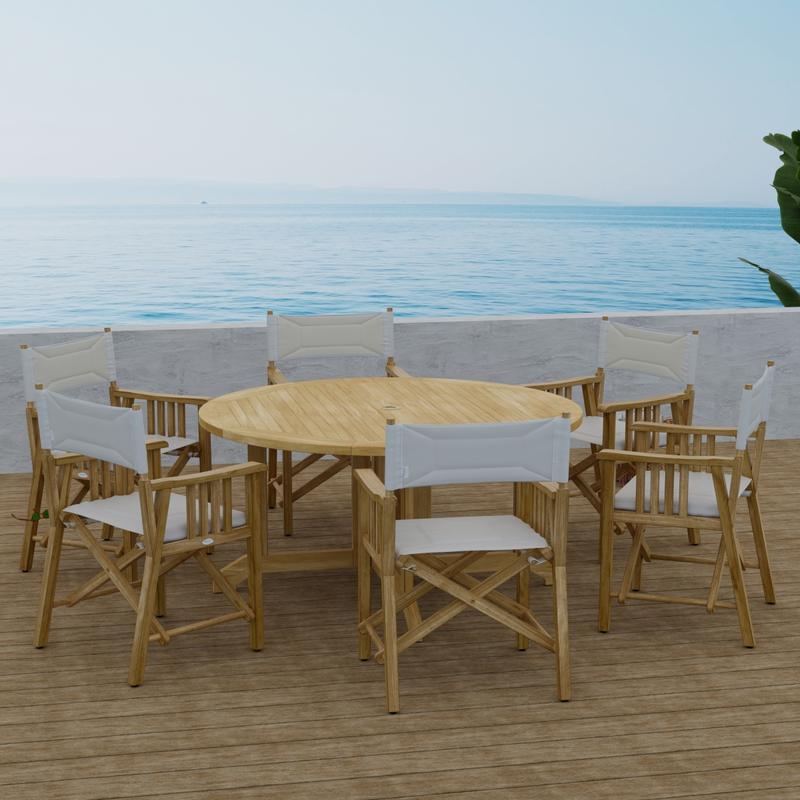 alt="70362 Barbuda Director 7 piece Teak Dining Set of 6 Director Chairs and Round 60 inch diameter folding teak dining table side view with ocean and blue sky background  "