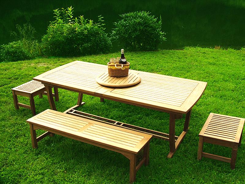 alt="70009 Grand Veranda teak picnic table set a teak lazy susan with wine bottle and basket top angle view on a grass lawn and landscaped background"