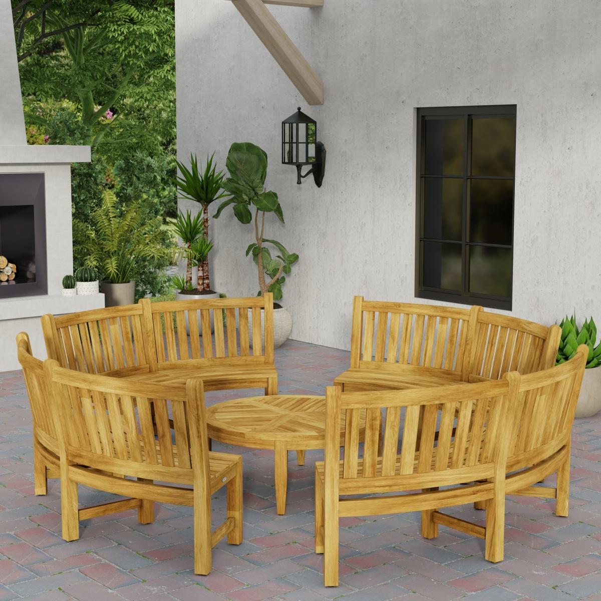 70862 Buckingham teak 6ft curved bench set of 4 in circle around the Laguna Coffee Table in side angled view on patio next to a fireplace with 4 potted plants in background