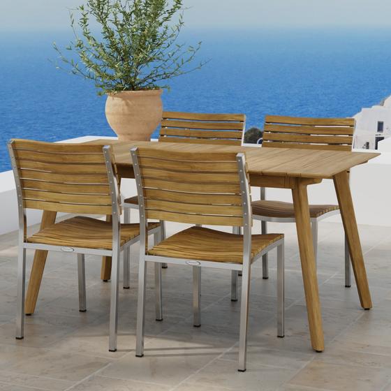 70552 Vogue Surf 5 pc Dining Set of Surf Table and 4 Vogue Side Chairs on outdoor terrace in angled side view with potted plant and ocean in the background