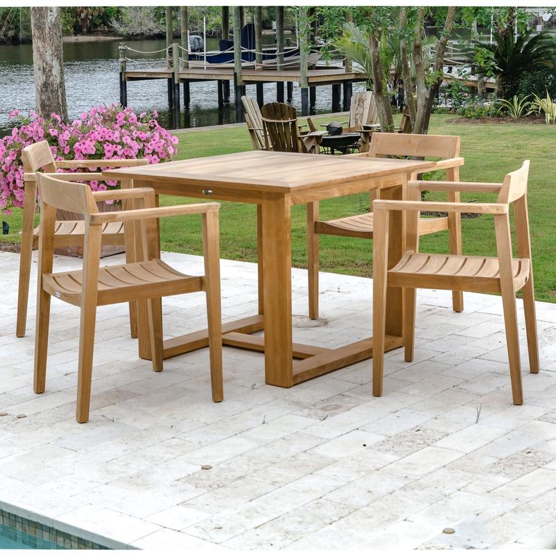 alt=" 70174 Horizon 5 piece Square Dining Set on pool paver deck with potted flowering plant and grass landscaped area and boat dock and lake in background"