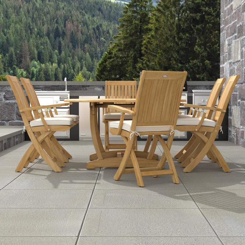 alt="70368 Martinique Oval Barbuda Chair 7 pc Dining Set of Martinique Oval Table and 6 Barbuda Teak Arm Chairs with optional cushions in end view on patio with trees in the background"