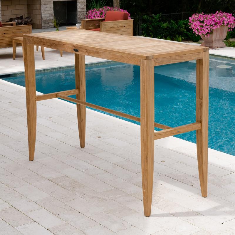 alt="15821 Laguna Teak  5 ft  Bar Table on patio pavers by pool with fireplace and two teak craftsman chairs in background"