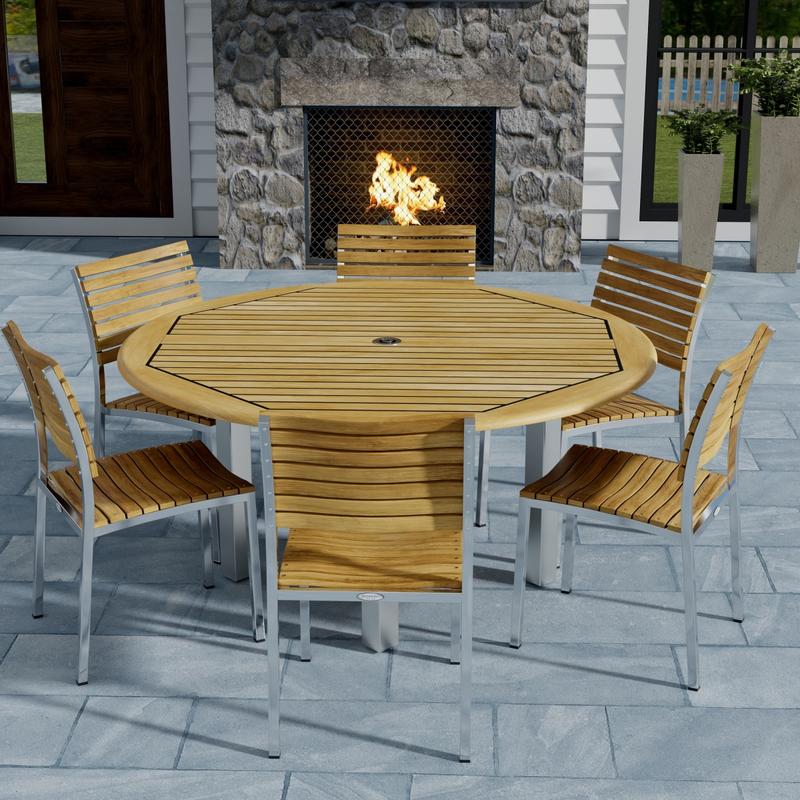 alt="70439 Vogue Dining Set for 6 of Vogue Teak and Stainless Steel 60 inch Round Dining Table and 6 Vogue Side Dining Chairs angled top view with an outdoor fireplace in the background "