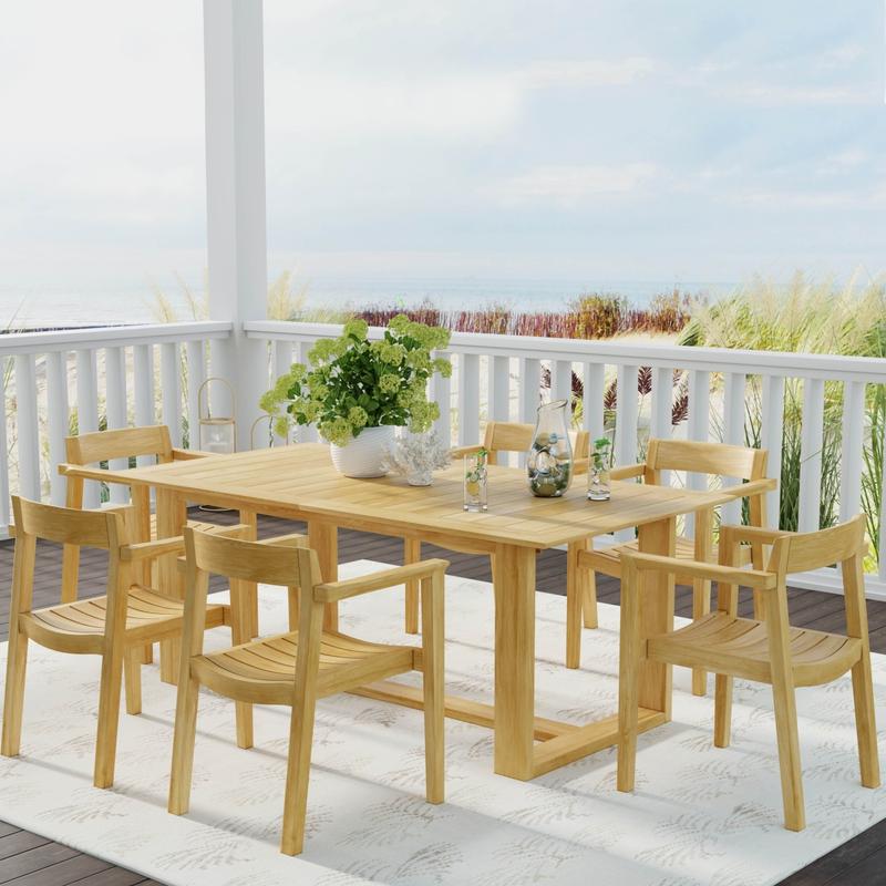 alt="70299 Horizon 7 pc Teak Dining Set in angled side view on covered patio with flower vase and drinking pitcher and 2 glasses on table with deck railing and trees in background "