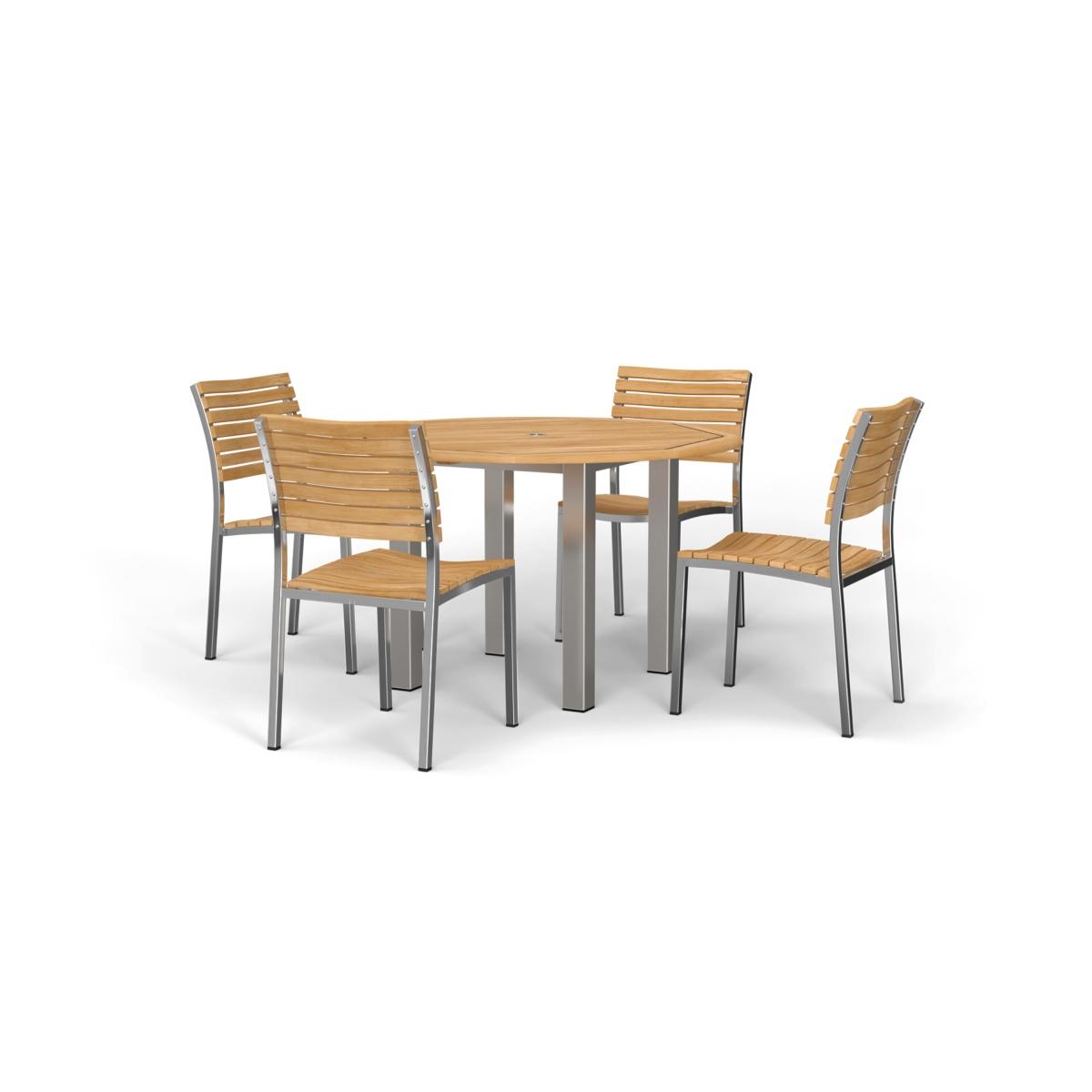 70438 Vogue Dining Set for 4 of Vogue Teak and Stainless Steel 48 inch Round Dining Table and 4 Vogue Stacking Dining Chair angled on patio with a door of house in the background