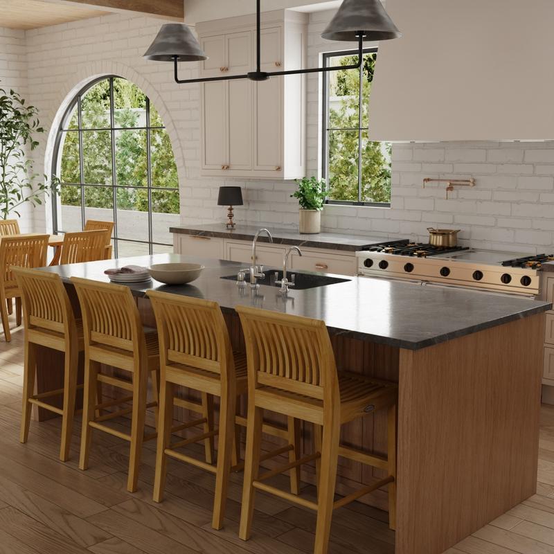 alt="70760 Laguna Teak Counter Stools Set of 4 on wood floor against a kitchen island with a stack of plates and kitchen sink angled side view with stove in the background"