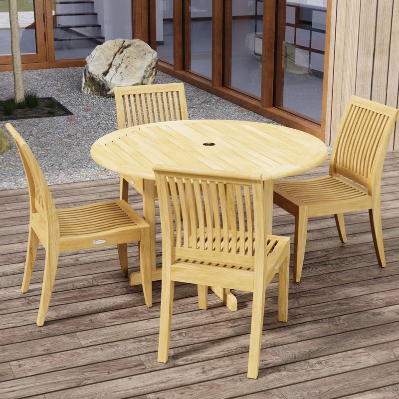 alt="70732 Barbuda Laguna 5 pc Teak Dining Set in angled top view on patio with trees and landscape rocks and french doors and windows of house in the background"