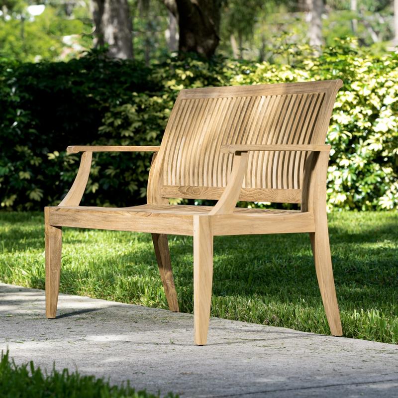 alt="13810 Laguna 4 foot Teak Bench side angled on walkway with grass and trees in background"