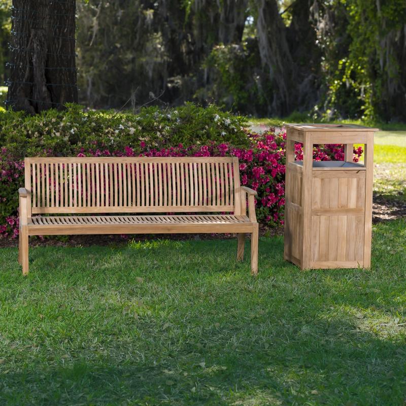 alt="13812 Laguna 5 foot long Teak Bench beside teak teak Palazzo III trash receptacle on grass with flowering shrubs and trees in background"