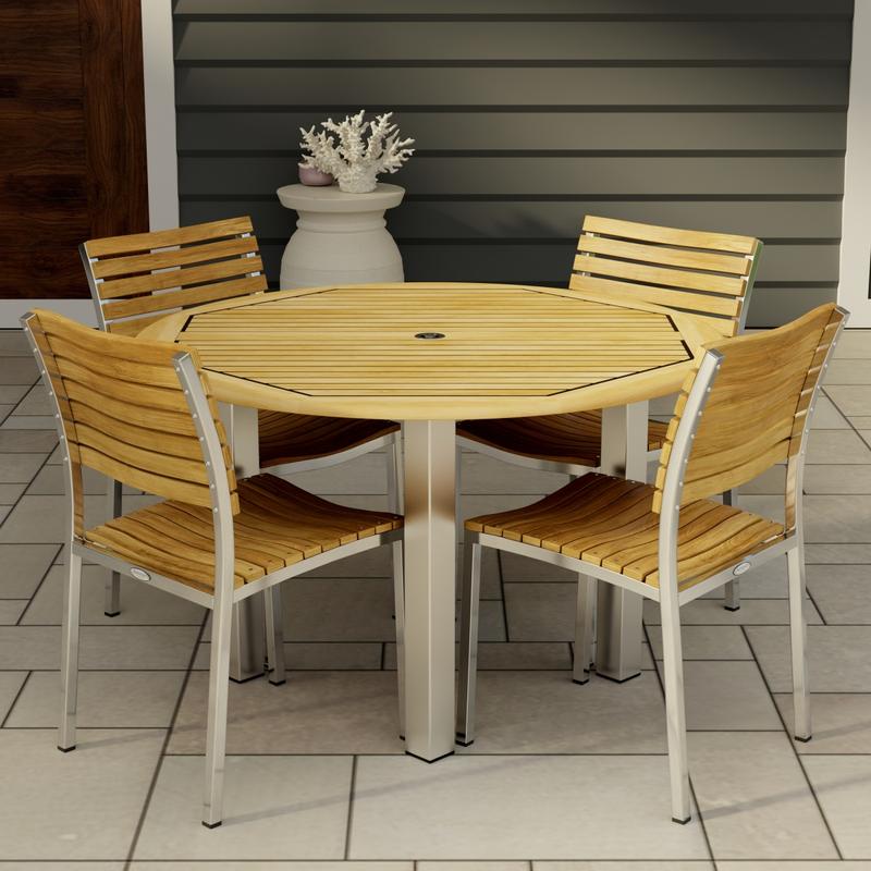alt="70438 Vogue Dining Set for 4 of Vogue Teak and Stainless Steel 48 inch Round Dining Table and 4 Vogue Stacking Dining Chair angled aerial view on tiled patio"