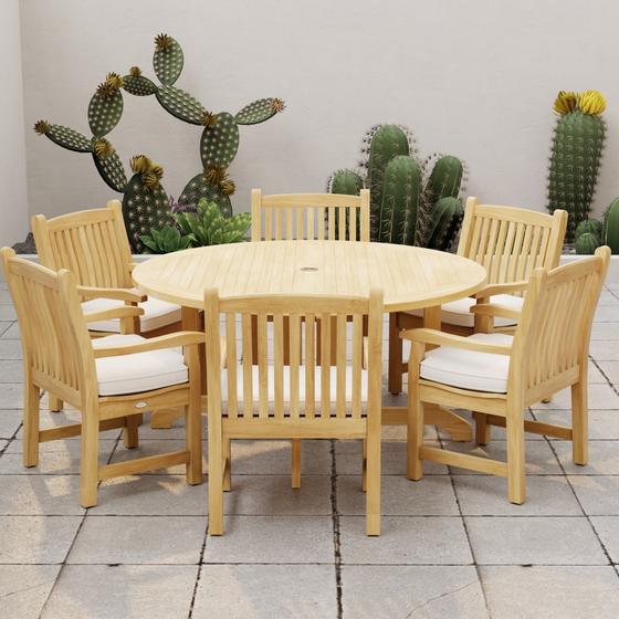 70350 Barbuda Veranda 7 pc Dining Set with optional seat cushions angled side view on stone patio with cactus plants against a privacy wall in the background 