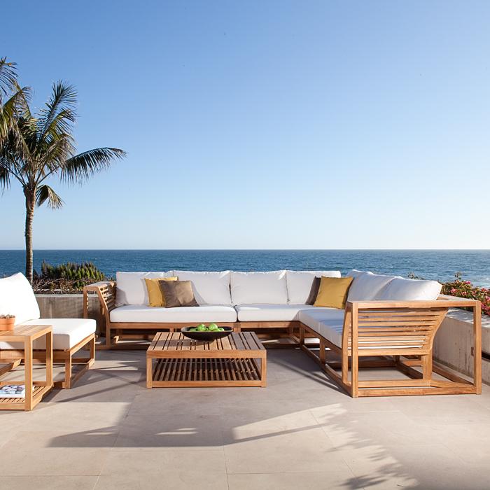 alt="70230 Maya deep seating collection with canvas cushions four throw pillows bowl of green apples a potted succulent magazine on tables on a concrete patio with palm trees and ocean views in background"