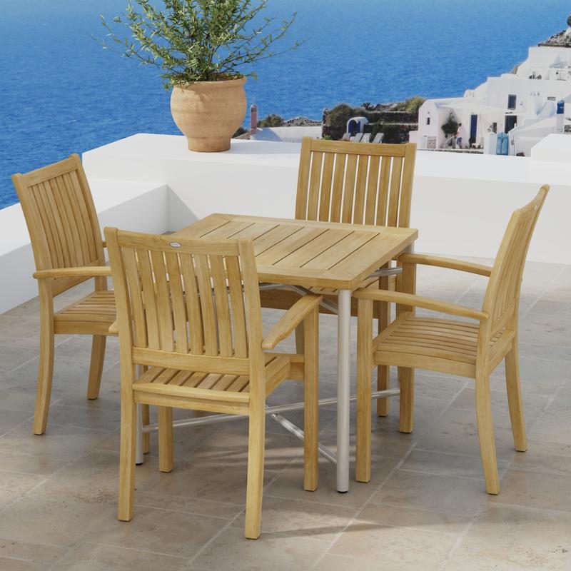 alt="70597 Odyssey Sussex 5 pc Dining Chair Set of Odyssey Square Table and 4 Sussex Dining Chairs in angled side view on tiled terrace with potted plant and homes and ocean in the background "
