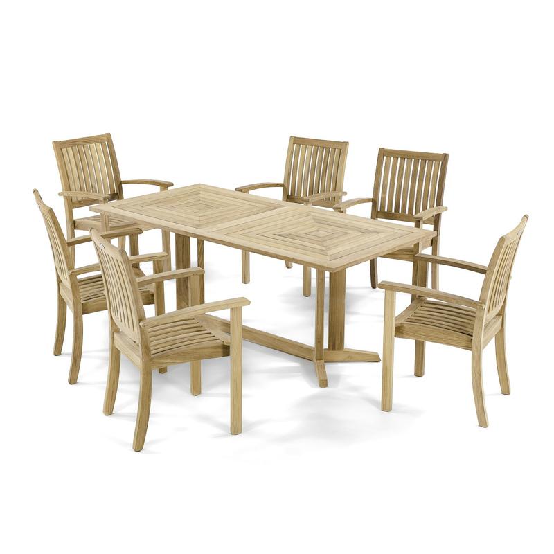 alt="12196 Sussex teak stacking armchair with round teak dining table on stone patio with trees and shrubs in background"