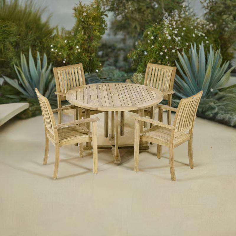 alt="70737 Sussex teak Round Dining Set angled top view with 4 Sussex Teak Armchairs and Teak 48 inch diameter Round Dining Table angled on patio with landscaping plants in the background"
