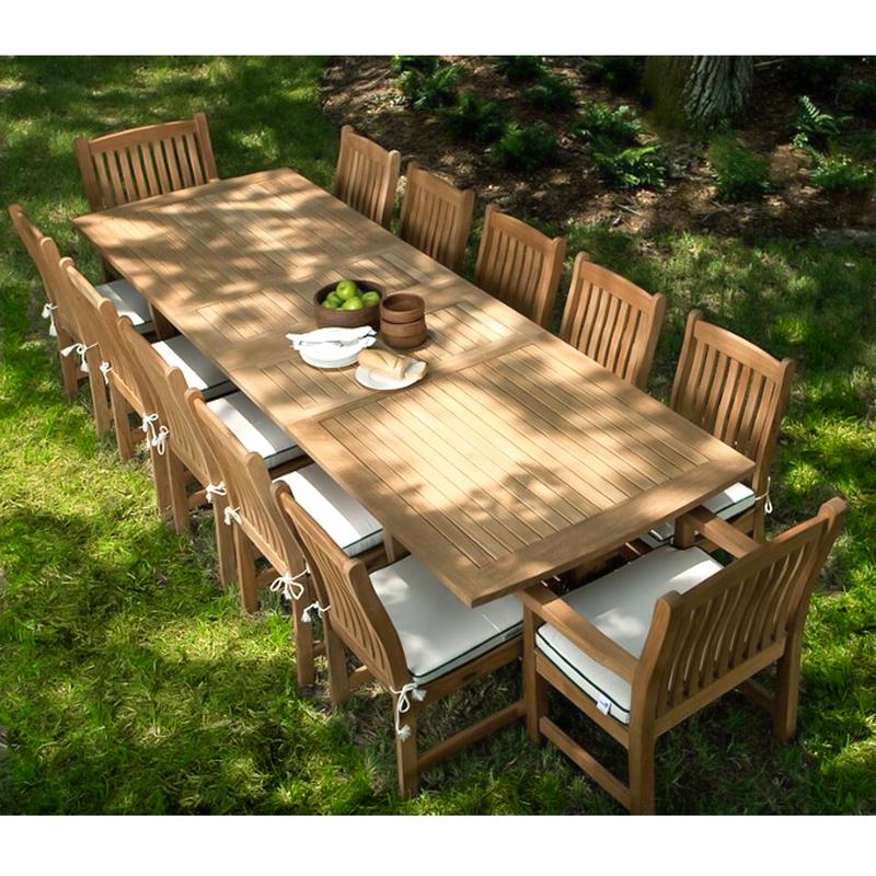 alt="70017 Grand Veranda 13 piece dining set with optional seat cushions in aerial view showing bowl of apples plate of bread serving plates and bowls on a grass lawn"