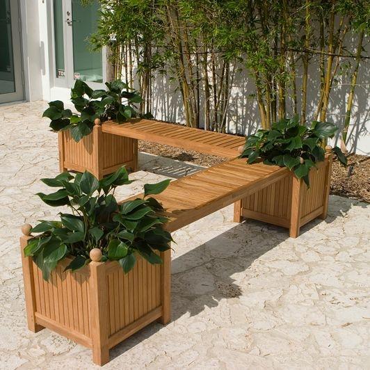 alt="18110 teak planter bench seat panel showing with three cube planters and two seat panels on concrete patio with shrubs and sliding glass doors in background"