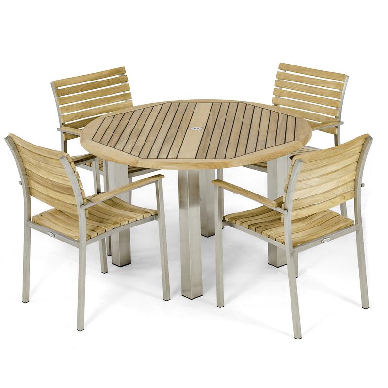 alt="70625 Vogue Round Teak Dining Set of  4 Vogue teak and stainless steel dining Armchairs around a Vogue 48 inch Round Teak Table in side angled view on white background "
