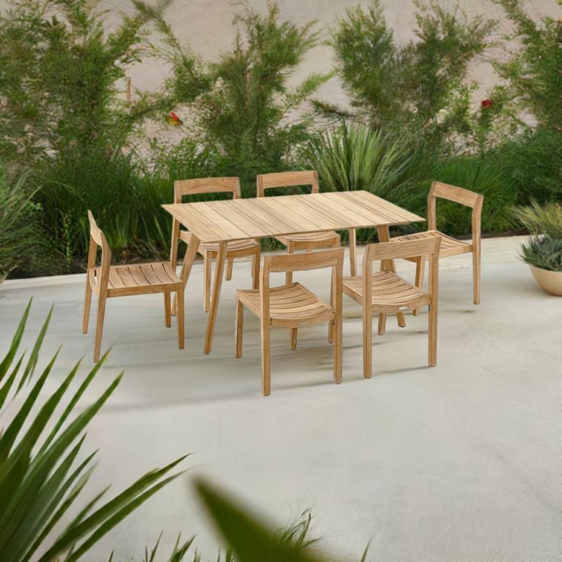alt="70527 Surf Horizon 7 piece teak Dining Set of 6 side chairs and teak 60 inch rectangular dining table angled aerial view on outdoor patio surrounded by landscaping plants in the background "