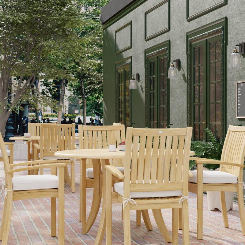 alt="70027 Grand Hyatt 5 pc Dining Set on brick patio showing 2 with table settings with optional seat cushions outdoors between landscape trees and store fronts in background"