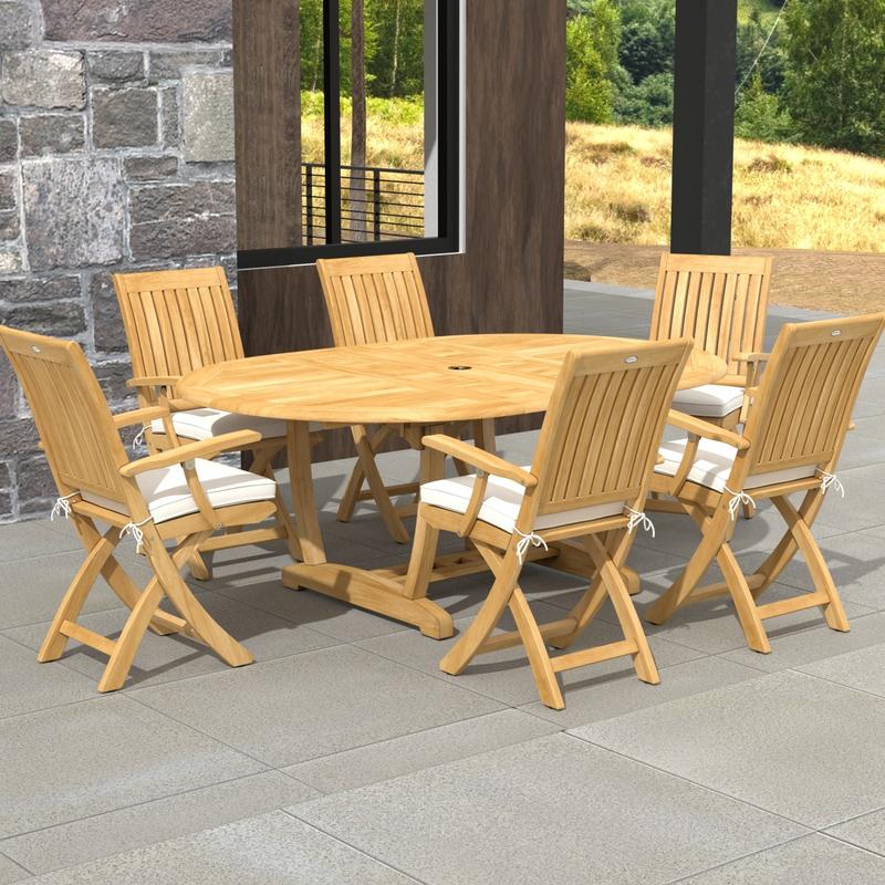 alt="70368 Martinique Oval Barbuda Chair 7 pc Dining Set with optional seat cushions in angled aerial view on outdoor patio with stone house and glass sliding doors in the background"