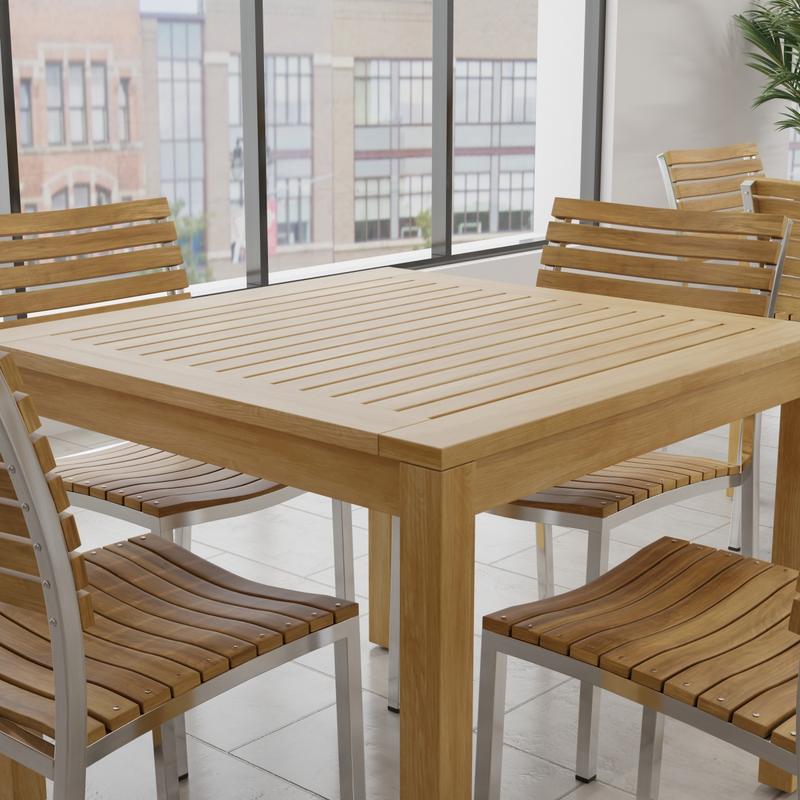 alt="70426 Vogue 5 piece Cafe Set of Bistro Teak 36" Square Dining Table and 4 Vogue teak and stainless steel side chairs in corner view with tall windows and buildings in background"