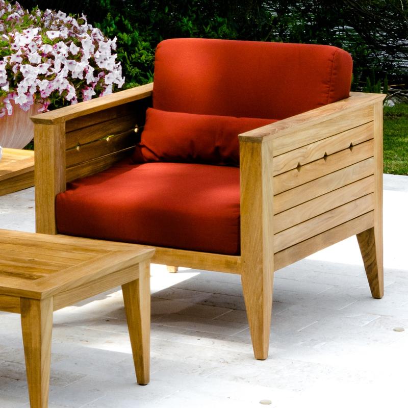alt="12160dp Craftsman teak cushioned armchair set front angled on concrete patio potted blooming plant and landscaped background"