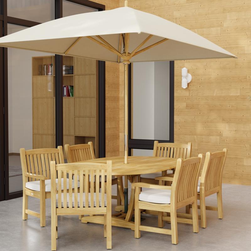 alt="70374 Oval Veranda Chair Dining Set of Martinique Teak Oval Table and 6 Veranda Dining Chairs angled end view with optional rectangular umbrella on outdoor terrace a glass door and window in background"