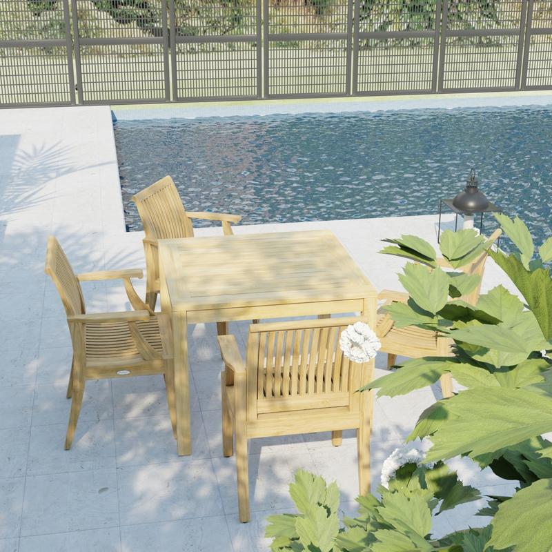 alt="70555 Laguna 5 pc Square Dining Set of Bistro 36 inch Square Teak Dining Table and 4 Laguna Dining Armchairs in angled view on pool deck with pool and fence in the background "