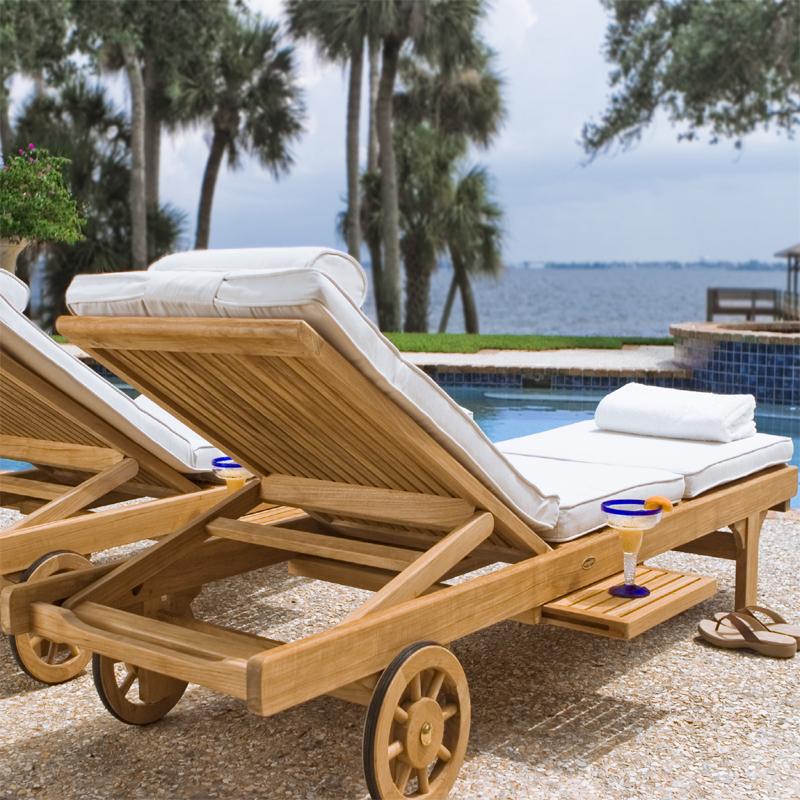 alt="16512s Somerset teak Chaise Lounger on stone patio with sandals next to chaise and back view showing two facing pool palm trees and ocean view in background"