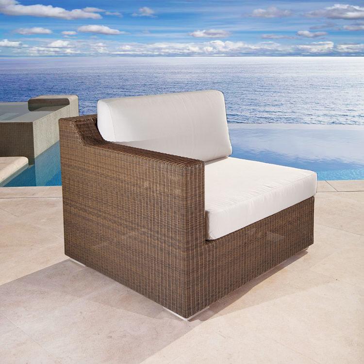 alt="31005 malaga synthetic wicker right side sectional with cushions side angle view on pool deck in front of a pool and ocean"