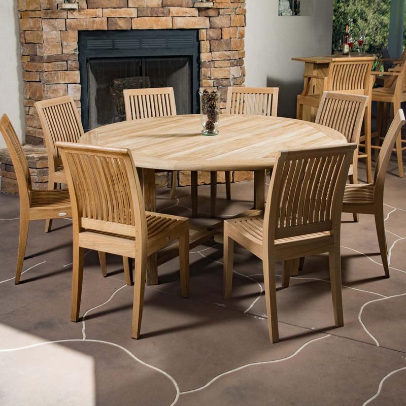 alt="70493 buckingham laguna nine piece teak dining set vase of pinecones on stone patio with stone fireplace teak bar set with wine bottle and two glasses in background"