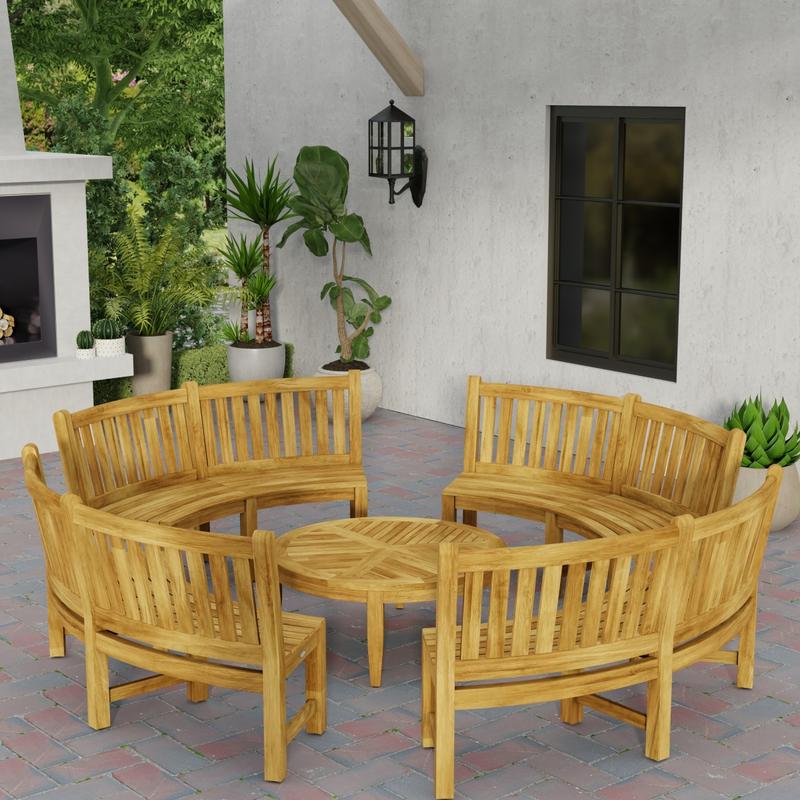alt="70862 Buckingham teak 6ft curved bench set of 4 in circle around the Laguna Coffee Table in angled aerial view on patio next to a fireplace with 4 potted plants in background  "