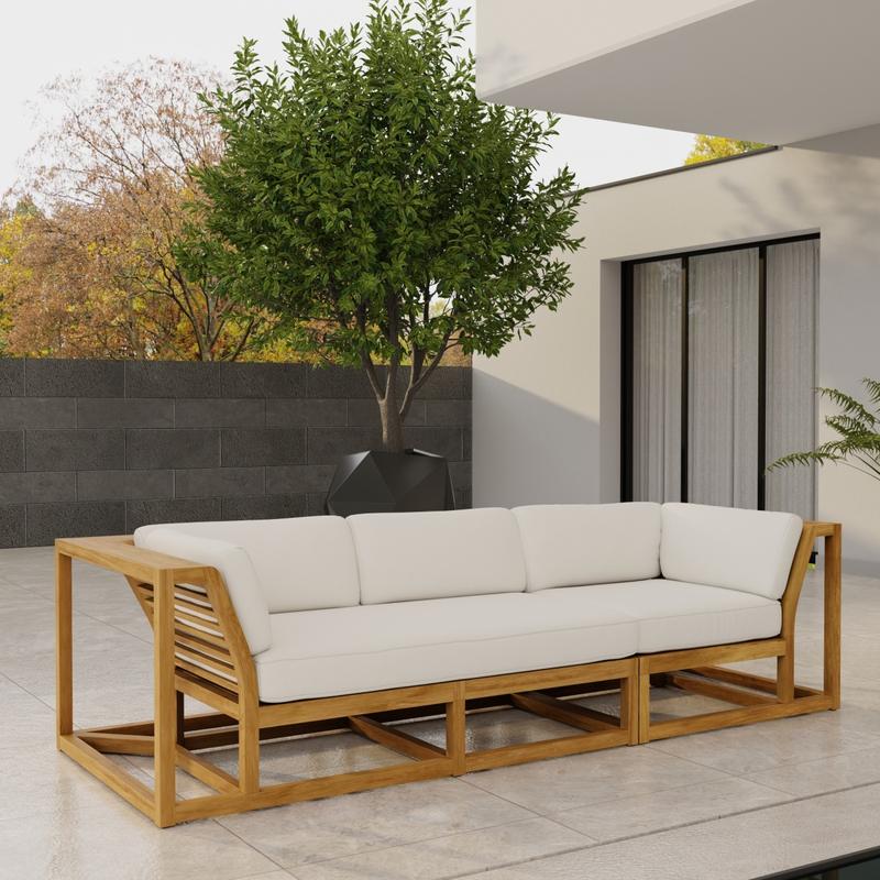 alt="70277 Maya Deep Seating Sofa of Maya Right Side Sofa Sectional and Corner Sectional in angled end view on patio next to glass door of house with fence and trees in background"