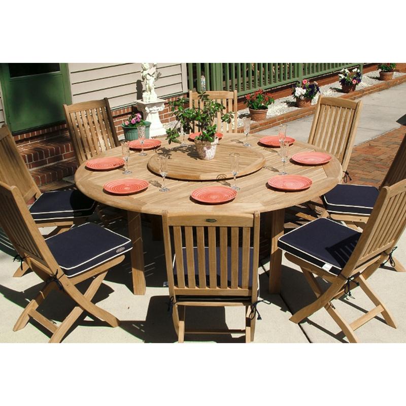 alt="70026 Buckingham Barbuda teak 9 piece Dining Set of teak 72 inch round dining table and 8 teak side chairs with optional Lazy Susan in center and 8 plates and 8 glasses on patio"