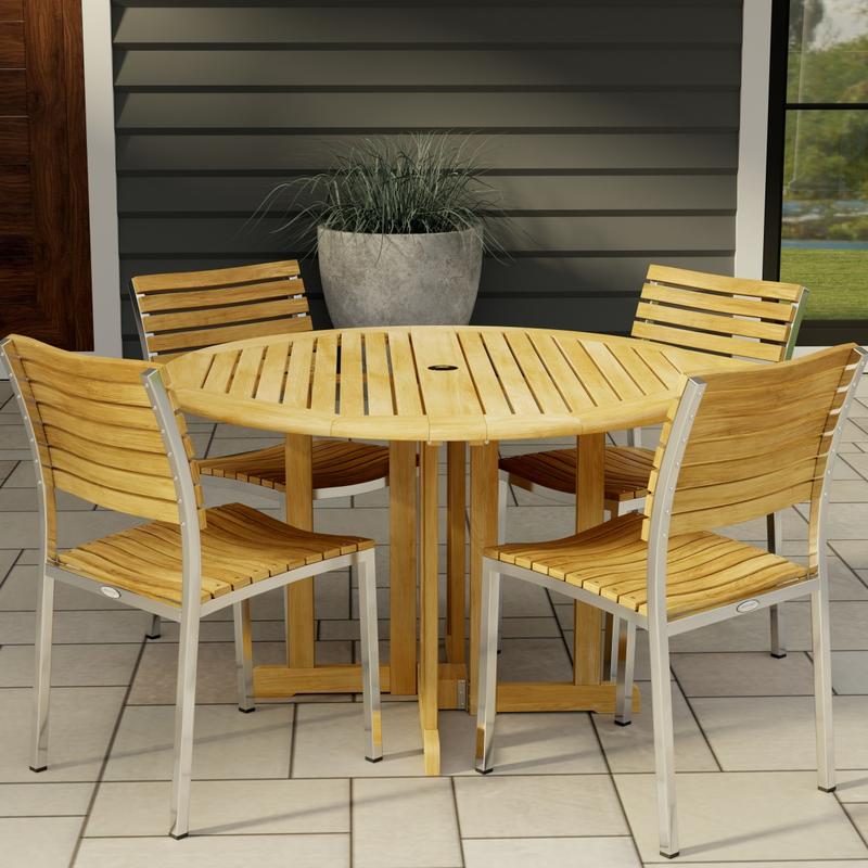 alt="70735 Barbuda Vogue 5 pc Teak DIning Set of Barbuda 48 inch Round Dining Table and 4 Vogue Teak and 304 Stainless Steel Side Chairs on tiled patio with potted plant and house in the background"