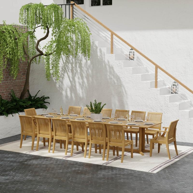 alt="70436 Grand Pyramid 15 piece teak Dining Set with 14 place settings and wine bottles on outdoor terrace patio next to landscape planter and in front of staircase to house"